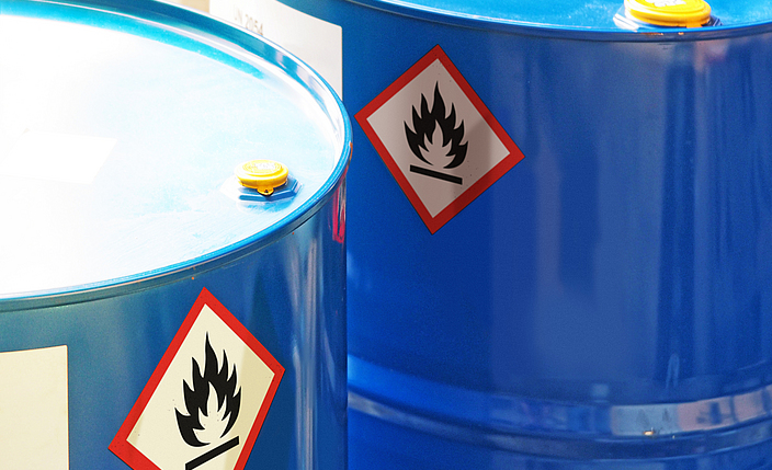 Zwei blaue Fässer mit dem Zeichen Gefahrstoffe, die auf einen leicht entzündbaren Inhalt hinweisen.
