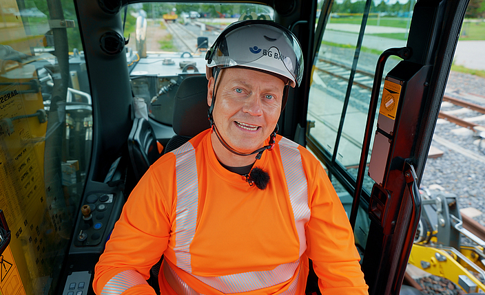 Porträt Denny Hillert, Aufsichtsperson der BG BAU, in einer Baumaschine.