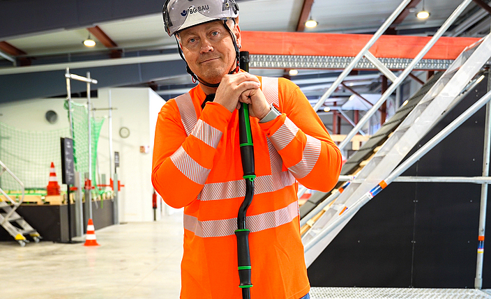 Denny zeigt einen Teleskopstiel fürs ergonomische Wischen.