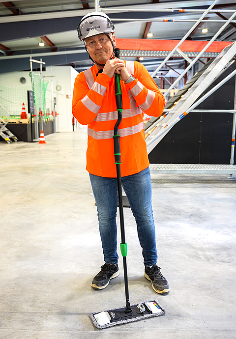Denny zeigt einen Teleskopstiel fürs ergonomische Wischen. 