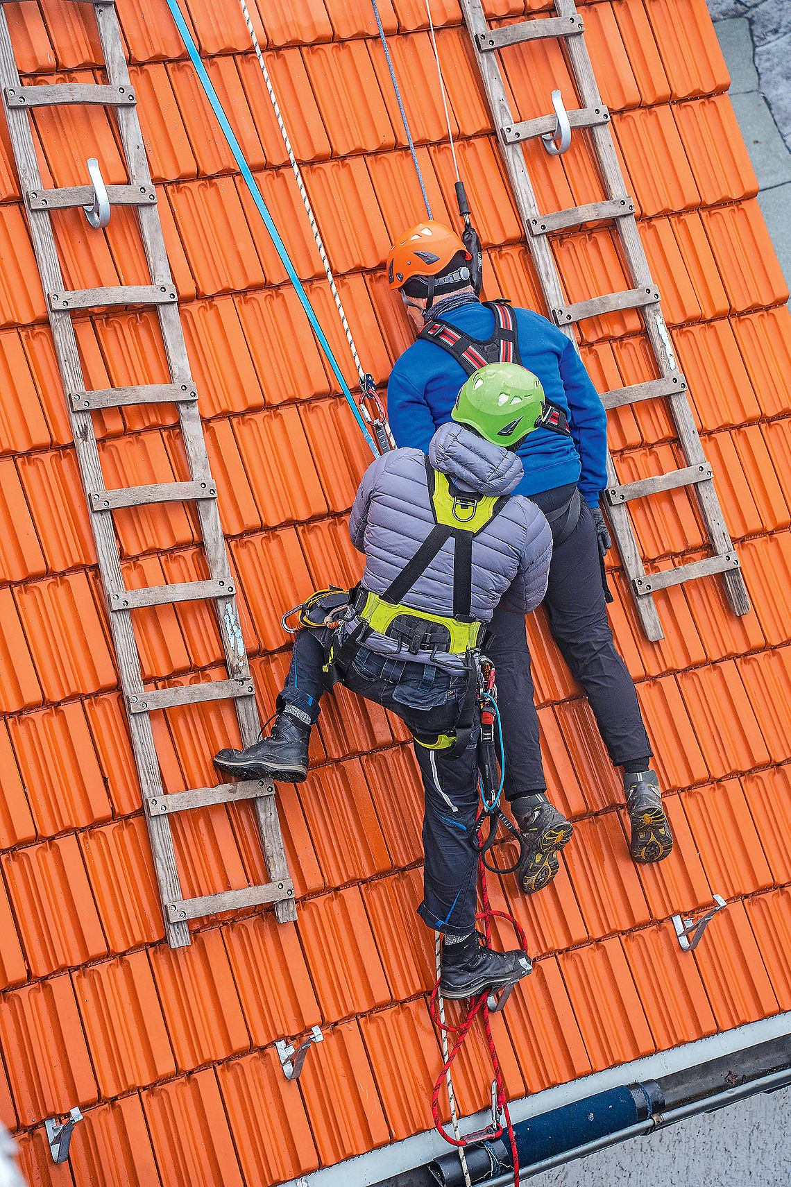 Trainer mit Dachdeckern bei der Unterweisung für Persönliche Schutzausrüstung gegen Absturz. 
