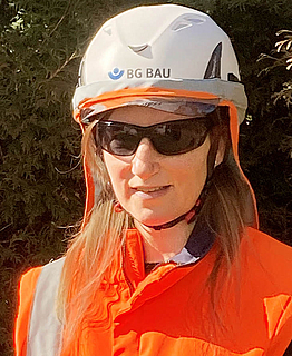 Porträt Susanne Iberle mit Schutzhelm und Sonnenbrille, Aufsichtsperson der BG BAU. 