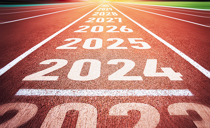 Auf einer Kunststoffbahn (Tartanbahn) stehen die Zahlen 2023, 2024, 2025, 2026, 2027, 2028 und 2029. 