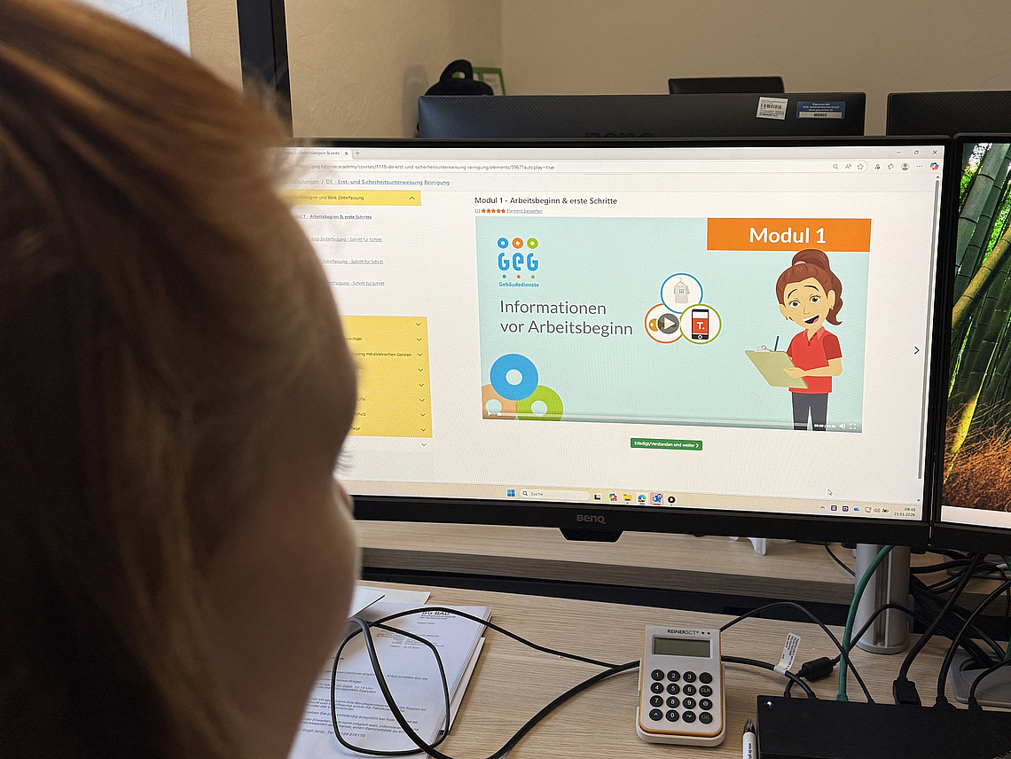 Gebäudereinigerin sitz vor Schulungsvideo von GEG Academy. 