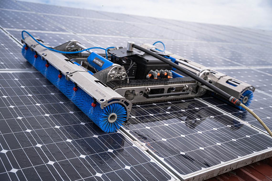 Reinigungsroboter Sun-X auf einer großflächigen Photovoltaik-Anlage.
