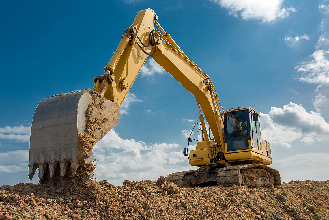 Ein Bagger schaufelt Sand.
