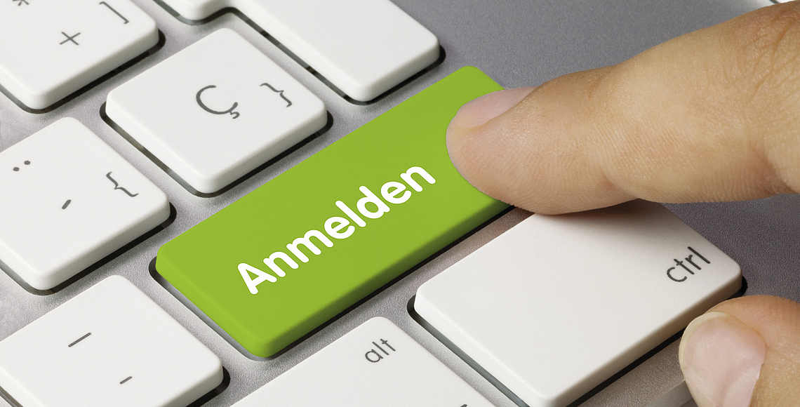 Ein Finger zeigt auf eine Tastaturtaste mit der Aufschrift: Anmelden.
