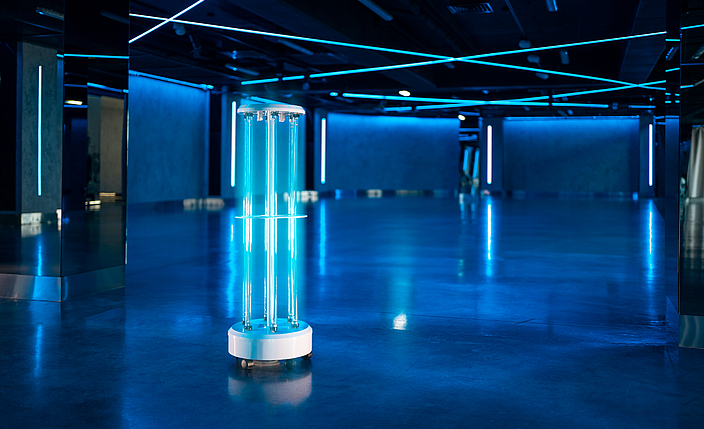 Maschine auf Rollen entfernt das Coronavirus mit UV-Licht in einer leeren Halle